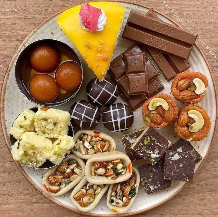 Overhead view of various chocolate desserts and sweets arranged on a white round plate