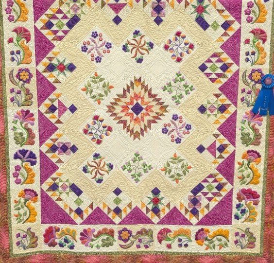Colorful patchwork quilt with geometric patterns, floral motifs, and a decorative border