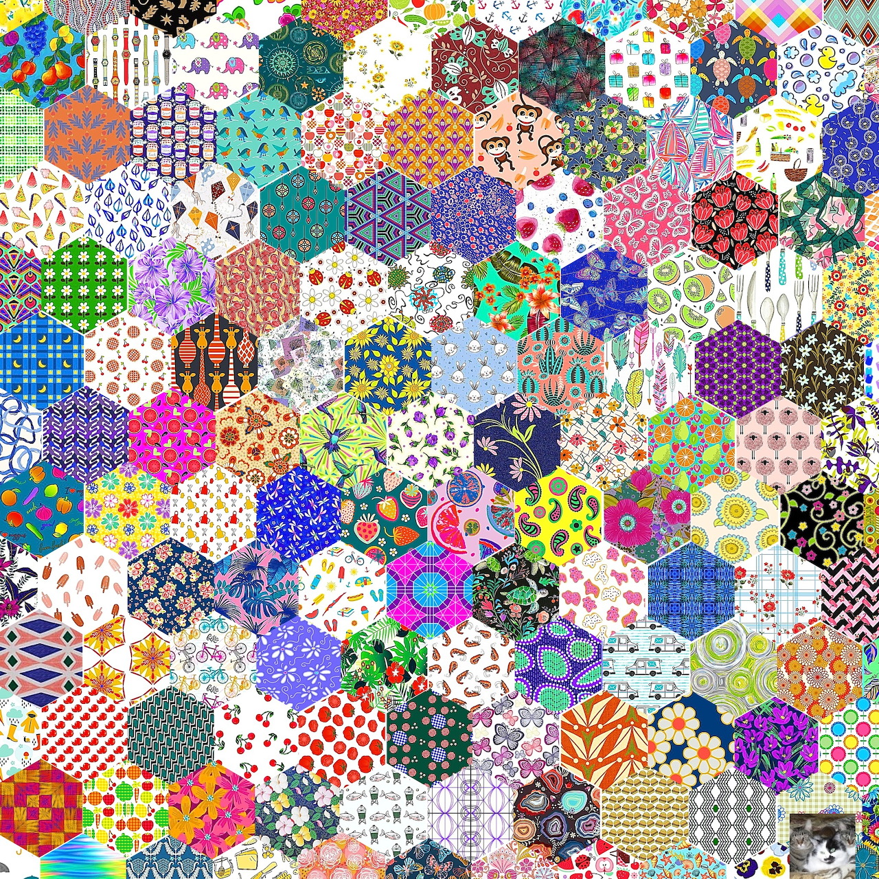 Dense hexagonal patchwork quilt with colorful fabric patterns including florals, dots, stripes and geometric designs