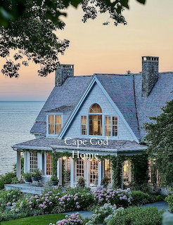 Gray shingled Cape Cod house with white windows surrounded by pink hydrangeas near the ocean at sunset