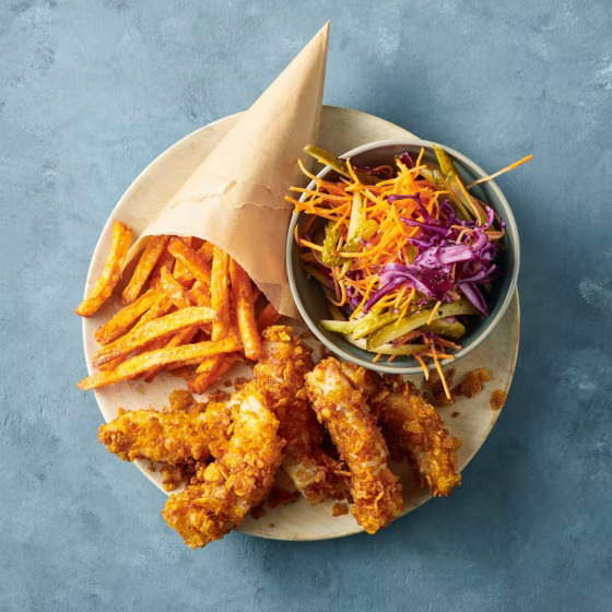 Plate of breaded fried fish with sweet potato fries and fresh coleslaw