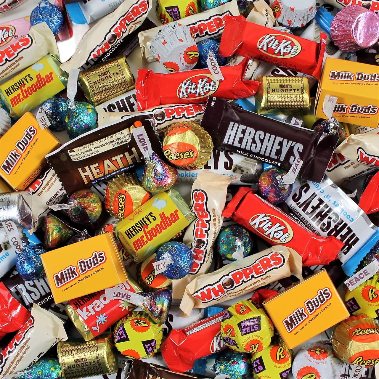Pile of assorted wrapped chocolate candy bars and sweets in colorful wrappers