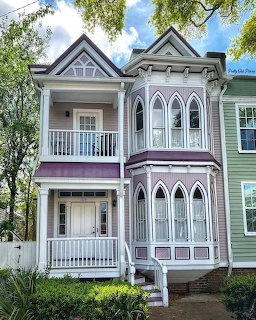 Colorful Victorian house with ornate trim, arched windows, balconies, and decorative architectural details
