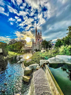 Cinderella Castle with dramatic sunset sky and stone bridge over moat