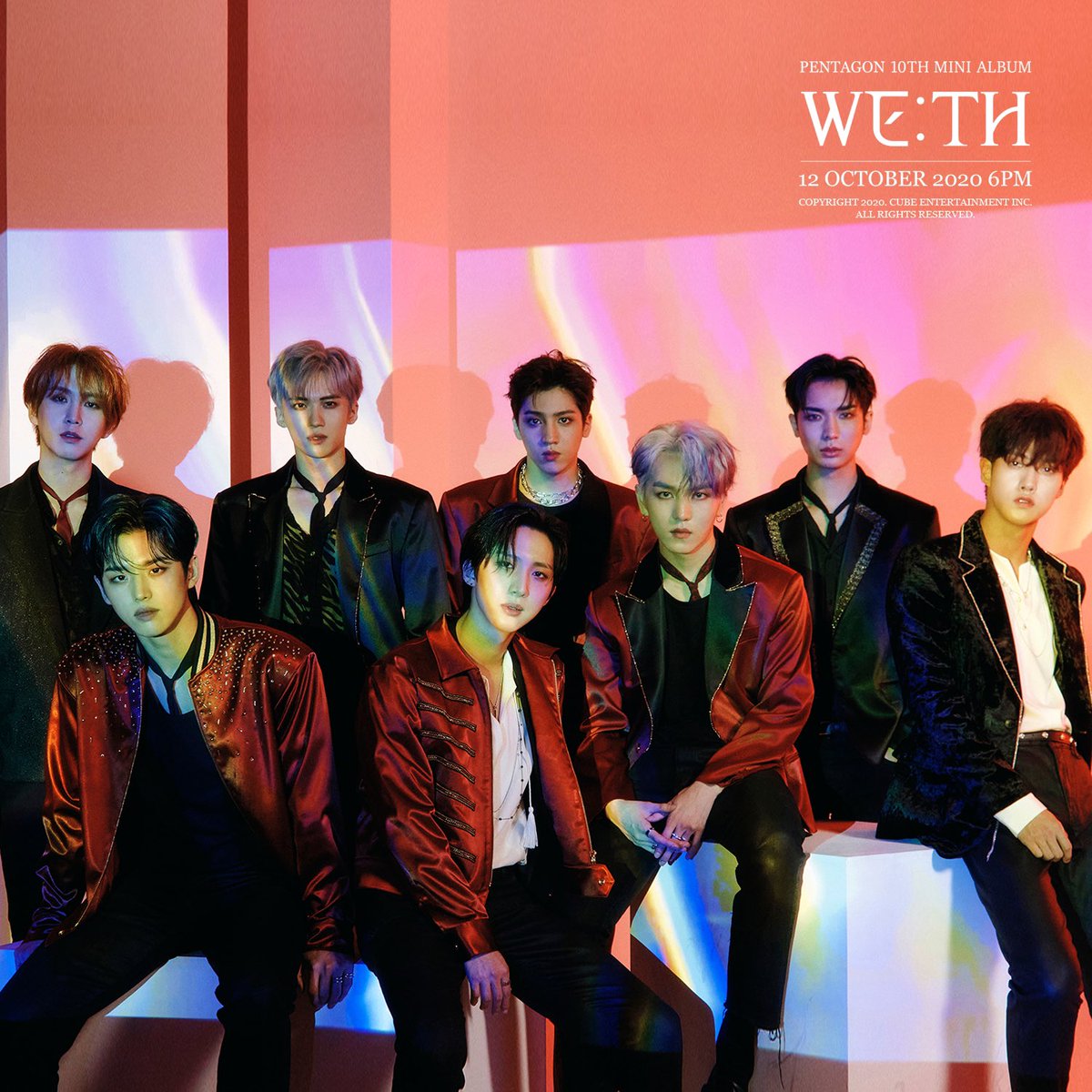Eight PENTAGON members pose in a studio with pink and orange lighting and WE:TH album text