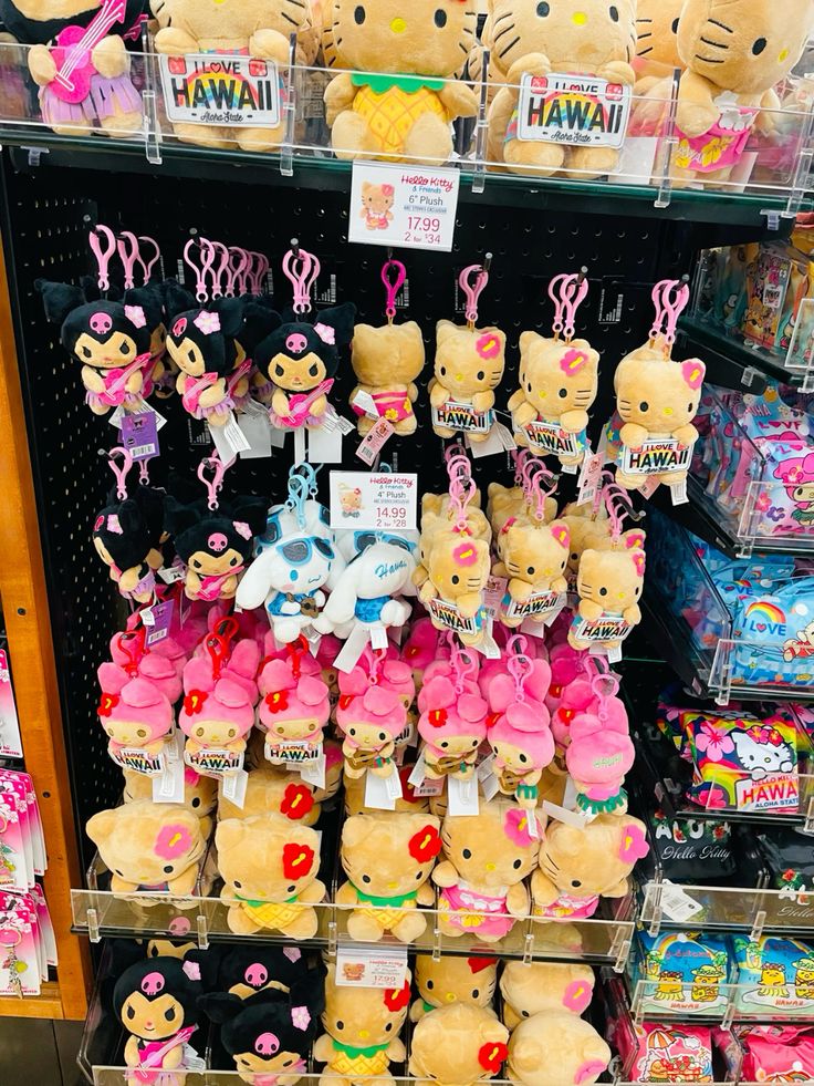 Store display of Hello Kitty Hawaii plush keychains and stuffed toys in pink and yellow