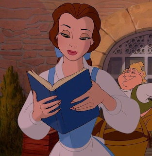 Belle in blue dress holding open book while walking through village