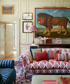 Elegant living room with large lion painting above a patterned sofa with colorful cushions