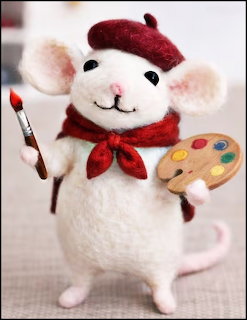 Needle-felted white mouse figurine wearing red beret and scarf, holding a paintbrush and paint palette