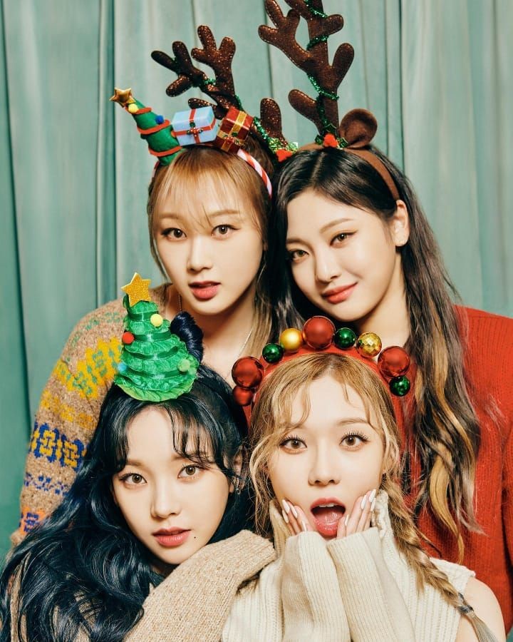 Four members of Aespa in winter holiday outfits with Christmas decor