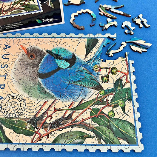 Illustrated blue bird on branches inside a stamp-shaped puzzle image