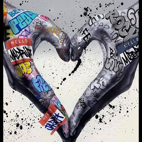 Two graffiti-covered arms form a heart shape on a white paint-splattered background