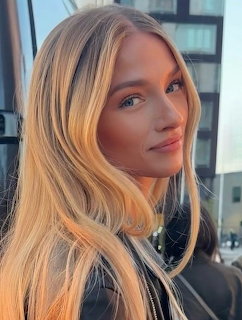 Portrait of blonde woman with blue eyes smiling at camera