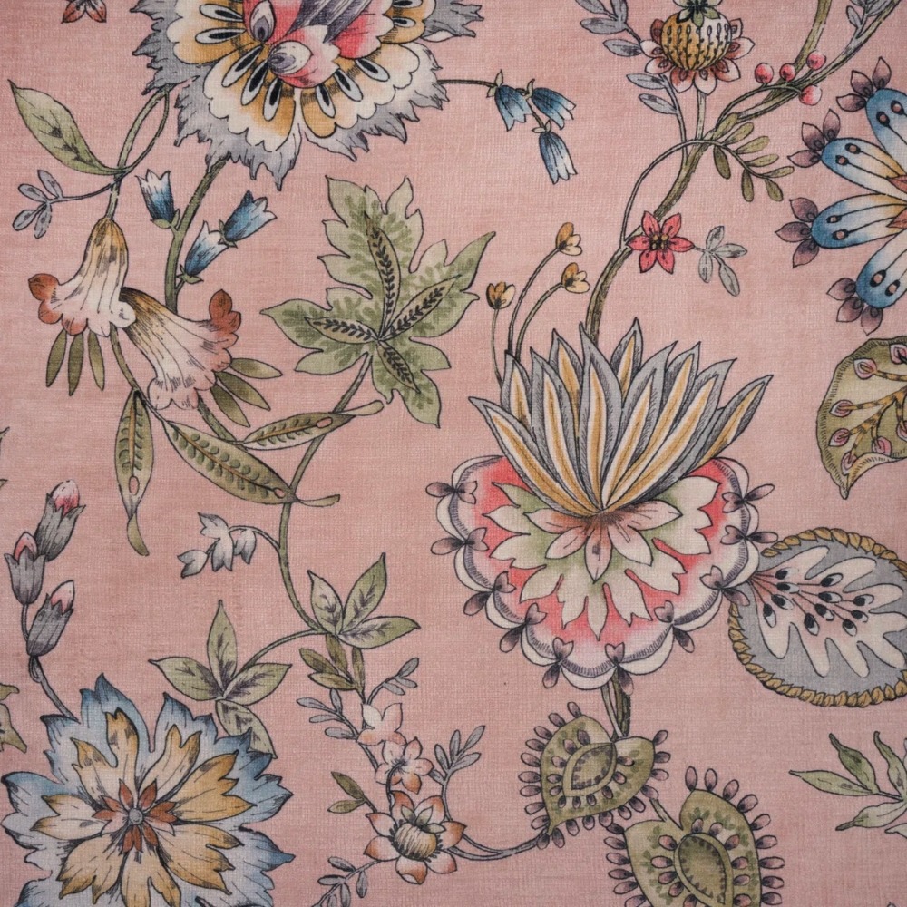 Pastel pink fabric with a detailed floral pattern of stylized flowers, leaves, and curling vines