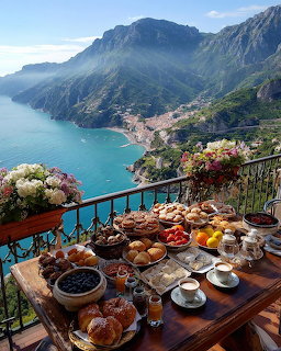 Breakfast table with pastries and coffee on a balcony overlooking the Amalfi Coast and mountains