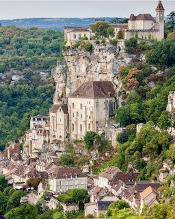 Cliffside church and stone village buildings in Rocamadour above a green valley