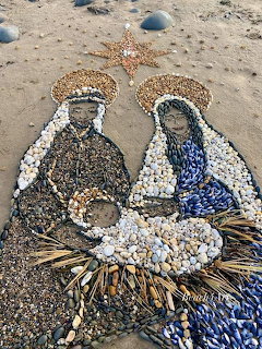 Seashell mosaic nativity scene with Mary, Joseph, and baby Jesus on beach sand