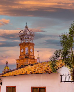 Ornate crown-topped bell tower of Parroquia de Guadalupe church at sunset in Puerto Vallarta
