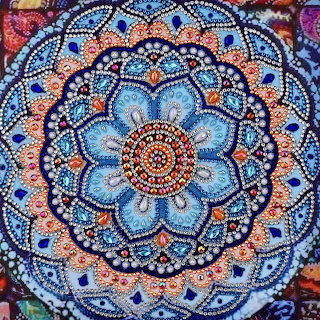 Blue and pink dotted mandala with intricate circular symmetrical patterns