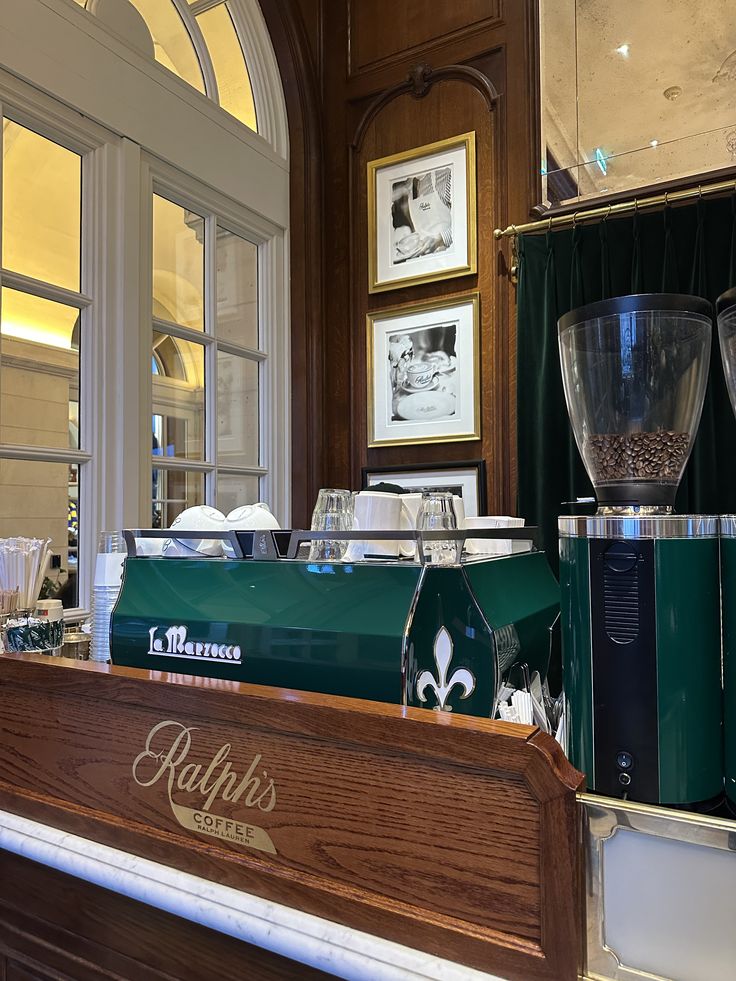 Ralph's Coffee café counter with green espresso machine, grinder, and framed photos on wall