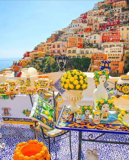 Colorful Positano hillside village viewed from a terrace decorated with lemons and Italian ceramics