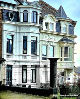Ornate white and green Belgian townhouses with turet and wrought iron fence in Verviers