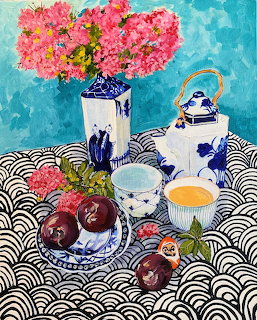 Colorful still life painting with pink flowers, blue pottery, teapot, plums on patterned tablecloth