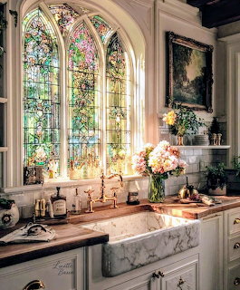 Elegant kitchen with colorful arched stained glass windows above white marble sink and wooden countertops