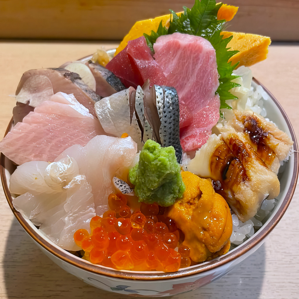 Colorful Japanese seafood bowl with fresh sashimi, salmon roe, and rice garnished with wasabi