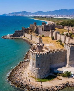 Aerial view of Mamure Castle with stone walls and towers along the turquoise Turkish coastline