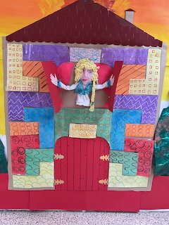 Colorful handmade paper house craft with puppet figure of a princess in the upper window