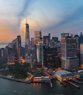 Aerial view of Lower Manhattan at dusk with One World Trade Center and waterfront buildings