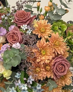 Mixed bouquet with pink roses, orange dahlias, purple flowers and greenery