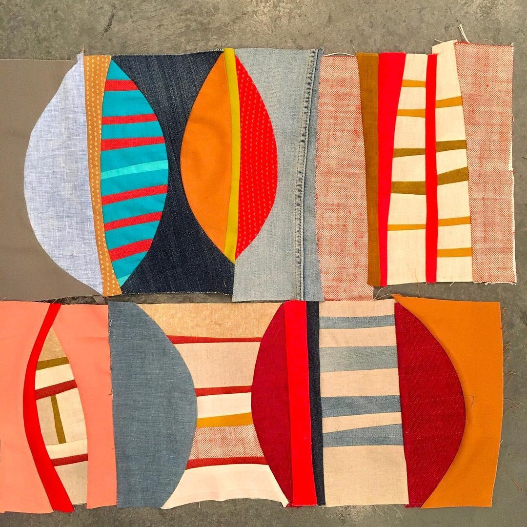 Four textile squares with geometric patterns in red, orange, blue, and cream on textured background