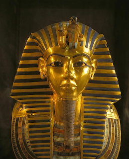 Golden mask of Pharaoh Tutankhamun with blue and gold striped headdress