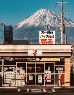 7-Eleven store with Mount Fuji rising behind it under a blue sky