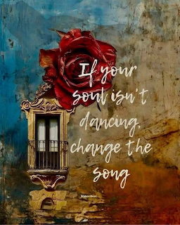 Red rose bloming from a vintage wall lantern on a textured blue and gold wall with inspirational text
