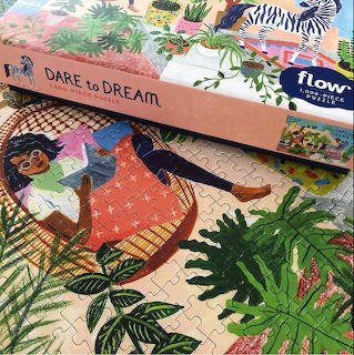 Boxed jigsaw puzzle with a colorful illustration of a woman reclining among tropical plants