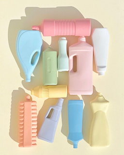 Pastel colored cleaning bottles, brushes and soap dispensers arranged on wall shelves