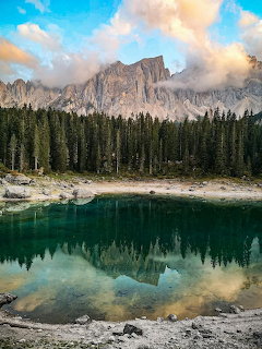 Rocky mountain and pine forest reflected in a calm turquoise lake