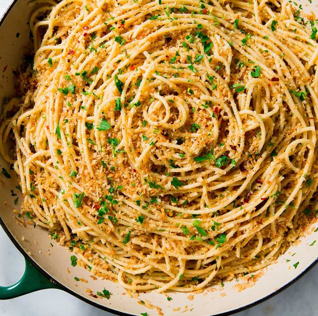 Top-down view of garlic parmesan spaghetti with herbs in white pan