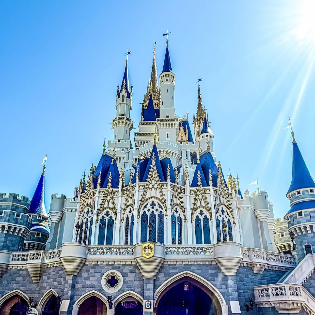 White castle with blue spires and turrets under bright blue sky