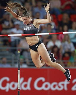 Canadian female athlete clearing a high jump bar in a stadium