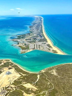 Aerial view of South Padre Island with sandy beaches, blue ocean, and turquoise lagoon