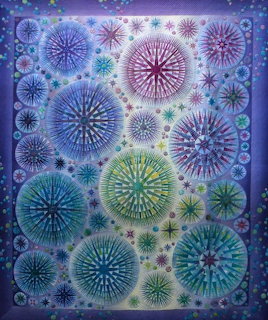Colorful quilt with overlapping circular mandala designs in blue, purple, green, and pink tones