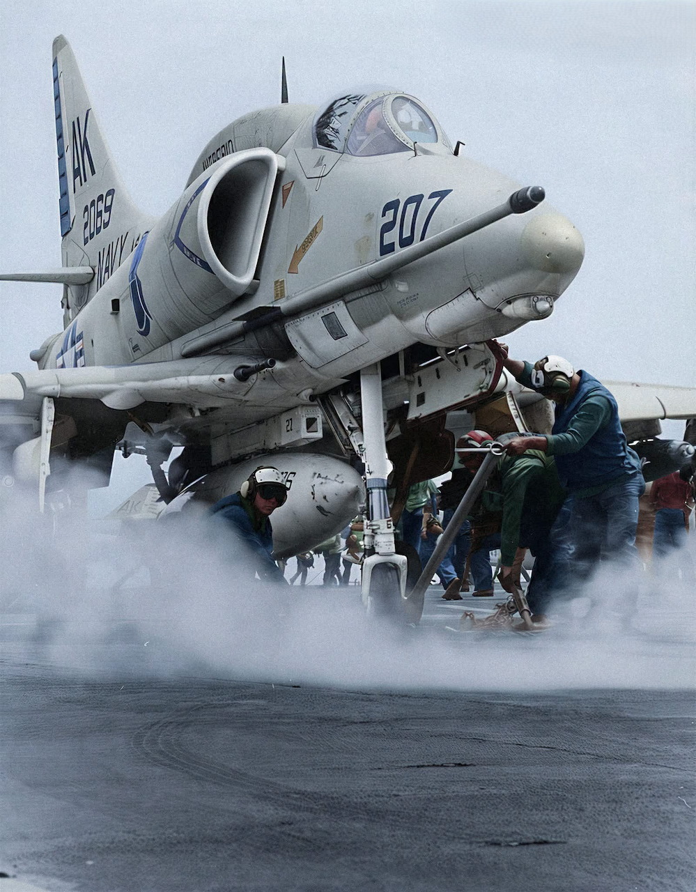 Douglas A-4E Skyhawk on a carrier deck surrounded by steam and naval crew