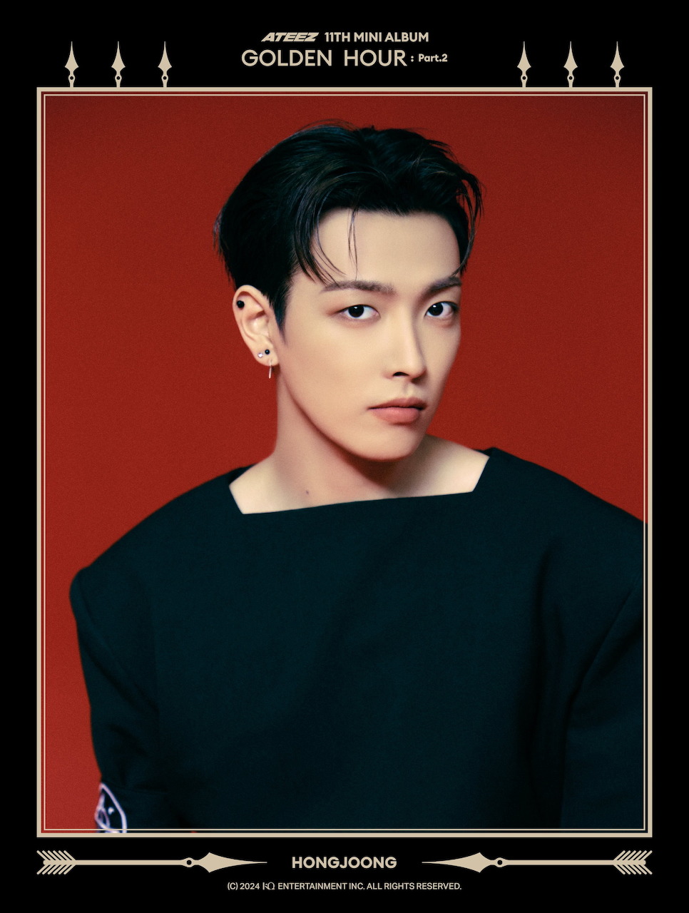 Hongjoong from ATEEZ posing in black top against red background with gold decorative frame