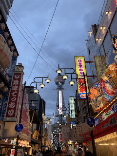 Osaka street at dusk with Japanese signs, lanterns, and colorful buildings
