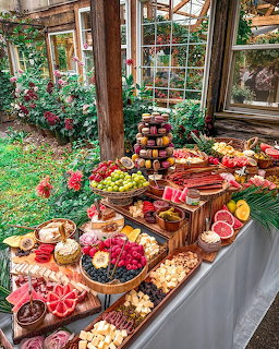 Outdoor dessert table with macarons, fruits, and pastries in garden setting