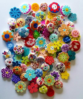 Colorful patterned wooden buttons with flowers and designs scattered on white background